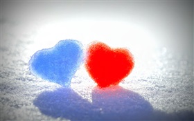 Corações azuis e vermelhos do amor na neve
