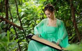 Vestido verde Menina asiática que joga a cítara