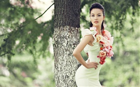 A menina bonita do vestido asiático, corpo esguio, flores