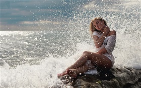 A menina loura, vestido branco, sentada nas pedras, mar, ondas, respingo de água