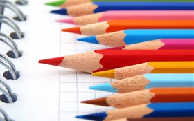lápis coloridos, notebook