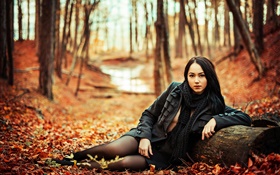 Menina do cabelo preto na floresta, outono, folhas amarelas