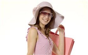 Menina de compra feliz, vestido cor de rosa, chapéu, óculos de sol