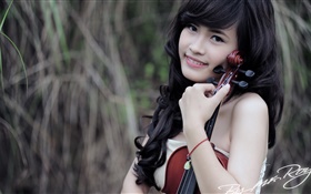 Sorriso asiático da menina, música, violino