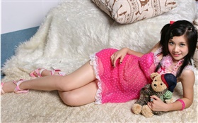 Sorriso vestido rosa menina asiática, cama, brinquedo