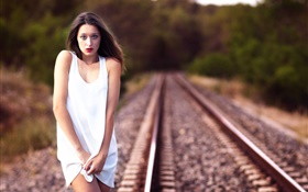 menina vestido branco na estrada de ferro