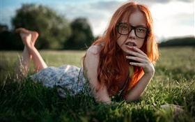cabelo vermelho da menina deitada grama, óculos