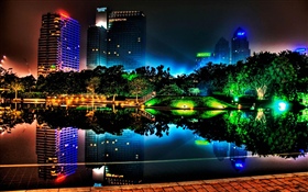 Cidade da noite bonita, edifícios, lagoa, luzes, árvores, parque